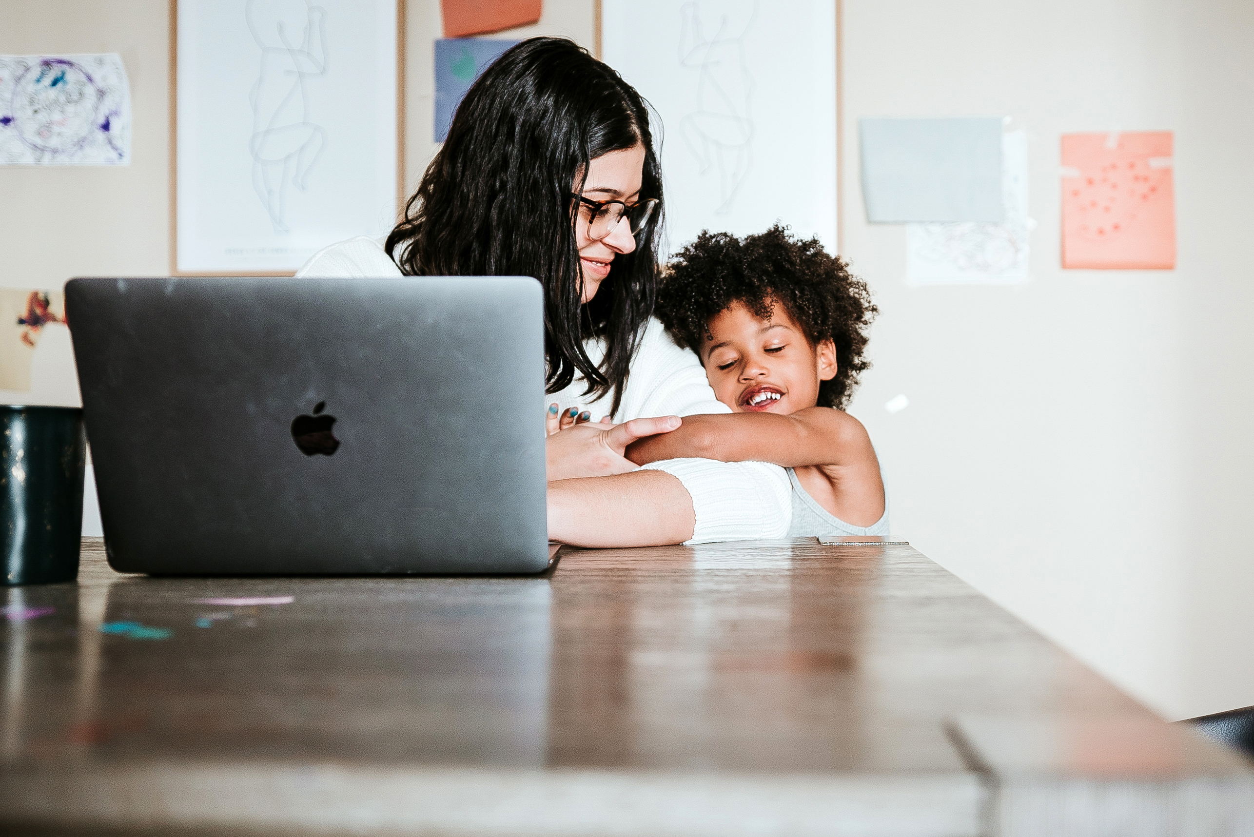 daughter hugging mom at computer